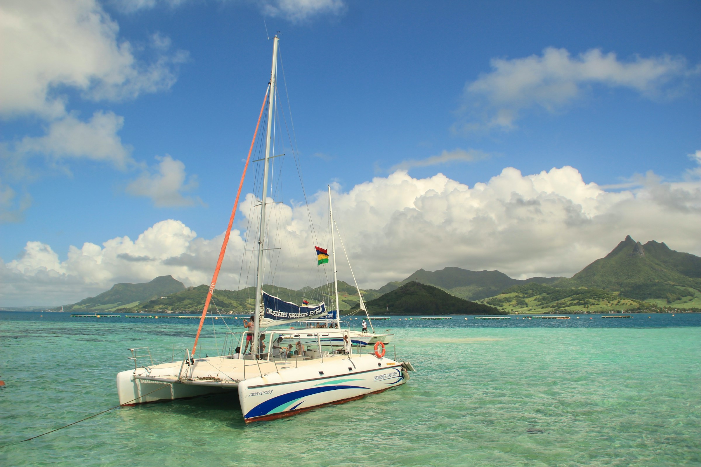 Catamaran sailing over turquoise water